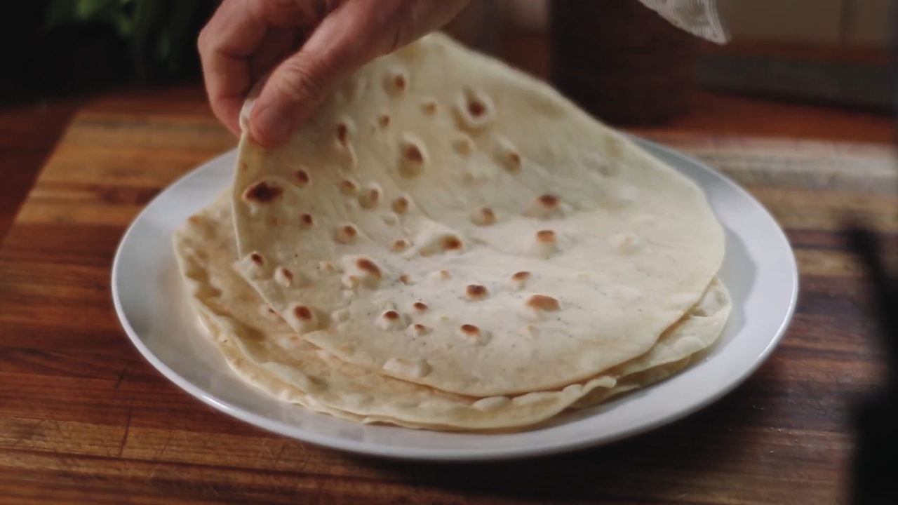 Tanke i mekane piadine sa zlatnosmeđim mrljama složene su na belom tanjiru